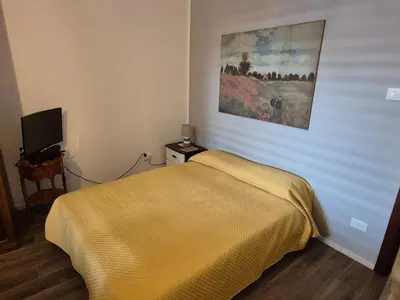 a bedroom with a bed and a painting on the wall at Casa Vacanza Mondello nel Cuore in Mondello