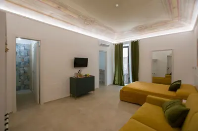 a hotel room with a bed and a couch at Massimo Rooms and suite in Palermo