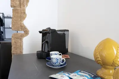 a table with a cup of coffee and a coffee maker at Le Volte Del Basile - 4 camere private e terrazza in Palermo