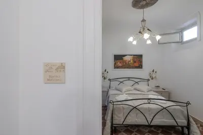 a bedroom with a bed and a chandelier at Le Volte Del Basile - 4 camere private e terrazza in Palermo