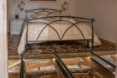 a bedroom with a metal bed with a glass floor at Le Volte Del Basile - 4 camere private e terrazza in Palermo