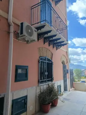 a pink building with a balcony and a window at Case Nereidi 1 in Porticello