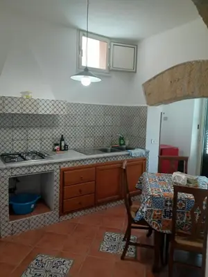 a kitchen with a sink and a table with a table sidx sidx at Case Nereidi 1 in Porticello