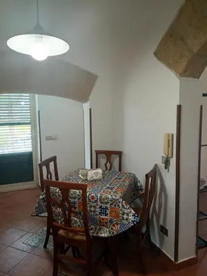 a dining room with a table and chairs and a lamp at Case Nereidi 1 in Porticello