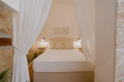 a bedroom with a white bed and curtains at House sea view in Terrasini