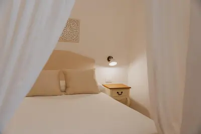 a bedroom with a white bed and a table at House sea view in Terrasini
