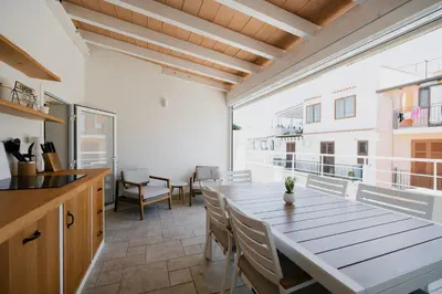 a kitchen and dining room with a large wooden table at House sea view in Terrasini