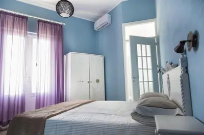 a bedroom with blue walls and a bed with purple curtains at Case Nereidi 2 in Porticello