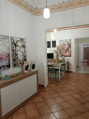 a living room with a table and a dining room at Mercury Apartment - 100 mq nel cuore di Palermo in Palermo