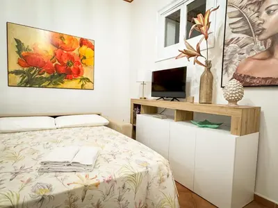 a bedroom with a bed and a painting on the wall at Mercury Apartment - 100 mq nel cuore di Palermo in Palermo