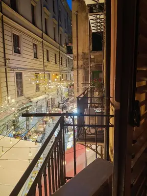 a balcony with a view of a street at night at Mercury Apartment - 100 mq nel cuore di Palermo in Palermo