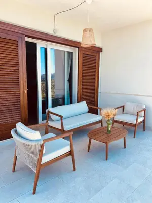 a patio with two chairs and a couch and a table at Villa Anthea - Relax vista mare tra Palermo e Cefalù in Trabia
