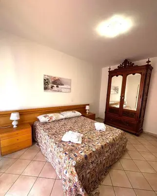a bedroom with a bed and a dresser and a mirror at Nelly's house in Terrasini