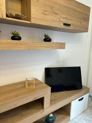 a tv on a wooden shelf with plants on it at Nelly's house in Terrasini
