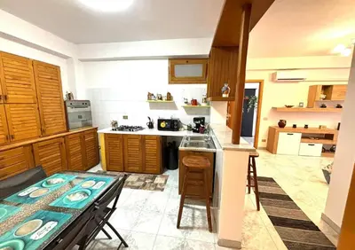 a kitchen with wooden cabinets and a table in it at Nelly's house in Terrasini