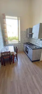 a kitchen with a table and a stove and a window at Casa Aurora G in Palermo