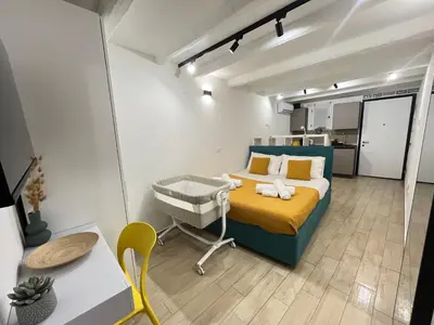 a bedroom with a bed and a chair in a room at La dolce casa in Palermo