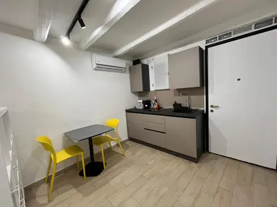 a small kitchen with a table and two yellow chairs at La dolce casa in Palermo