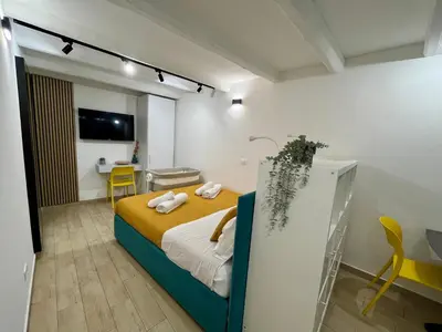 a bedroom with a bed and a desk in a room at La dolce casa in Palermo