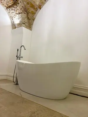 a white bath tub sitting in a room at Addimura rooms in Palermo