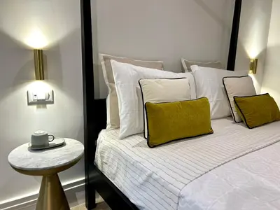 a bedroom with a bed with white and yellow pillows at Addimura rooms in Palermo