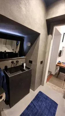 a bathroom with a black sink and a blue rug at Suitt Drims 8 in Palermo