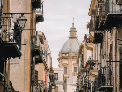 a view of a cathedral from between buildings at Suitt Drims 8 in Palermo