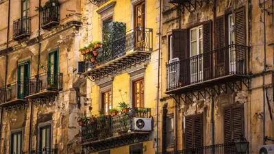 an old building with balconies and windows and a speaker at Suitt Drims 8 in Palermo