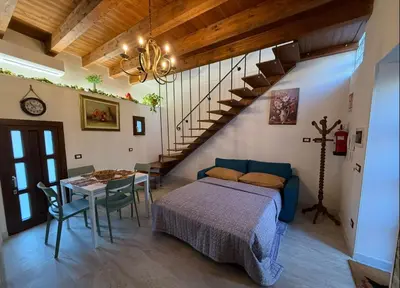 a bedroom with a bed and a table and a staircase at Cortile Cipriani in Palermo