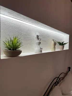 a shelf with potted plants on a wall at Cortile Cipriani in Palermo