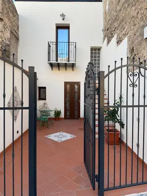 a courtyard with a wrought iron gate and a building at Cortile Cipriani in Palermo