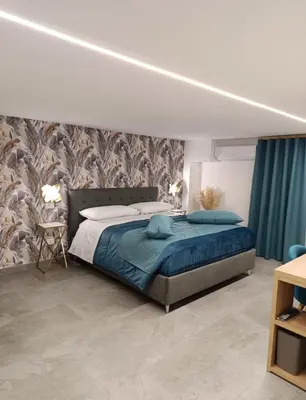 a bedroom with a large bed with blue pillows at Home Luxury Felice Marine in Palermo