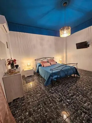 a bedroom with a bed and a blue ceiling at Oasi Ballarak in Palermo