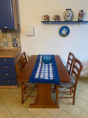 a wooden table with chairs and a bowl on it at San Vito Suite Apartament in San Vito lo Capo