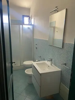 a bathroom with a sink and a toilet and a mirror at San Vito Suite Apartament in San Vito lo Capo