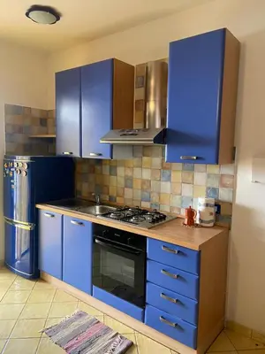 a kitchen with blue cabinets and a stove top oven at San Vito Suite Apartament in San Vito lo Capo