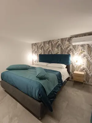 a bedroom with a large bed with blue sheets at Home Luxury Felice in Palermo