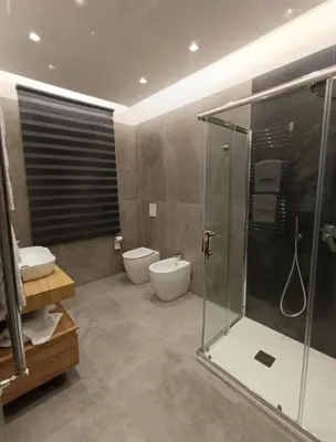 a bathroom with a shower and a toilet and a sink at Home Luxury Felice in Palermo