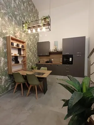 a kitchen with a wooden table and green chairs at Home Luxury Felice in Palermo