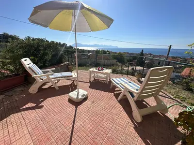 two chairs and an umbrella on a brick patio at Villa Belvedere in Partinico