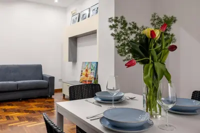 a living room with a table with a vase of flowers at Cortile Benso Guest House in Palermo