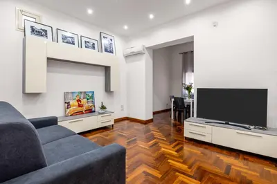 a living room with a couch and a flat screen tv at Cortile Benso Guest House in Palermo