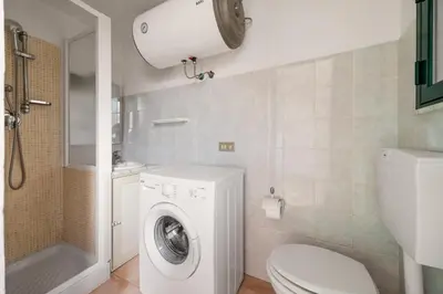 a bathroom with a washing machine and a toilet at Cortile Benso Guest House in Palermo