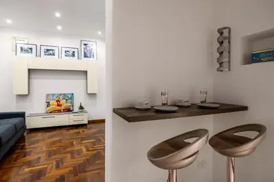 a living room with two stools and a couch at Cortile Benso Guest House in Palermo