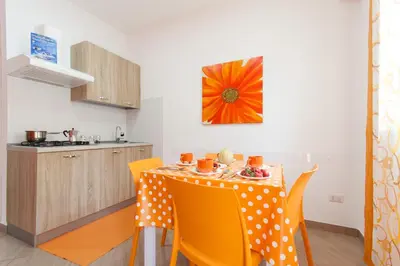 a kitchen with a table with yellow chairs in a room at Casa Vacanze del Golfo in Castellammare del Golfo