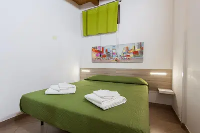 a room with a green bed with two towels on it at Casa Vacanze del Golfo in Castellammare del Golfo