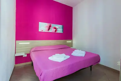 a pink bedroom with a pink bed with towels on it at Casa Vacanze del Golfo in Castellammare del Golfo