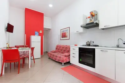 a kitchen with a red chair and a table at Casa Vacanze del Golfo in Castellammare del Golfo