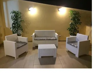 three white chairs and a table in a room at Casa Vacanze del Golfo in Castellammare del Golfo