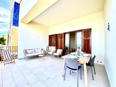 a patio with a table and chairs on a balcony at Riva Marina, sulla spiaggia in Alcamo